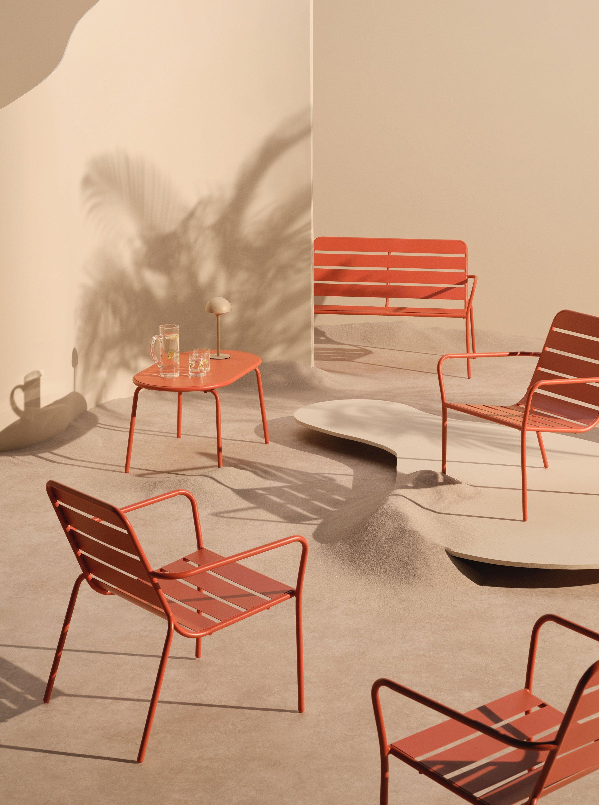 lots of orange metal chairs in a beige set up backdrop