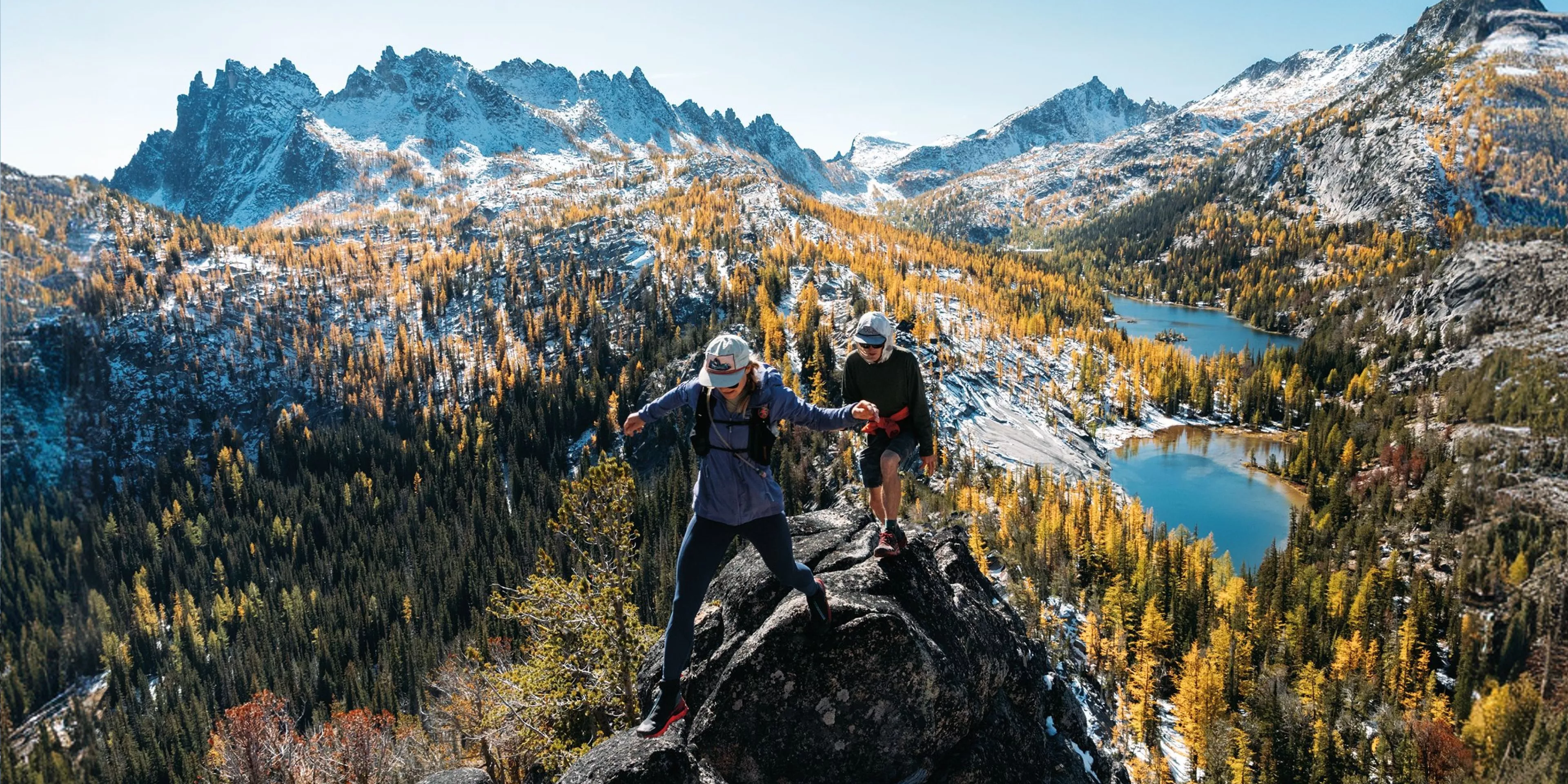 2 people hiking with a beautiful mountain view behind them