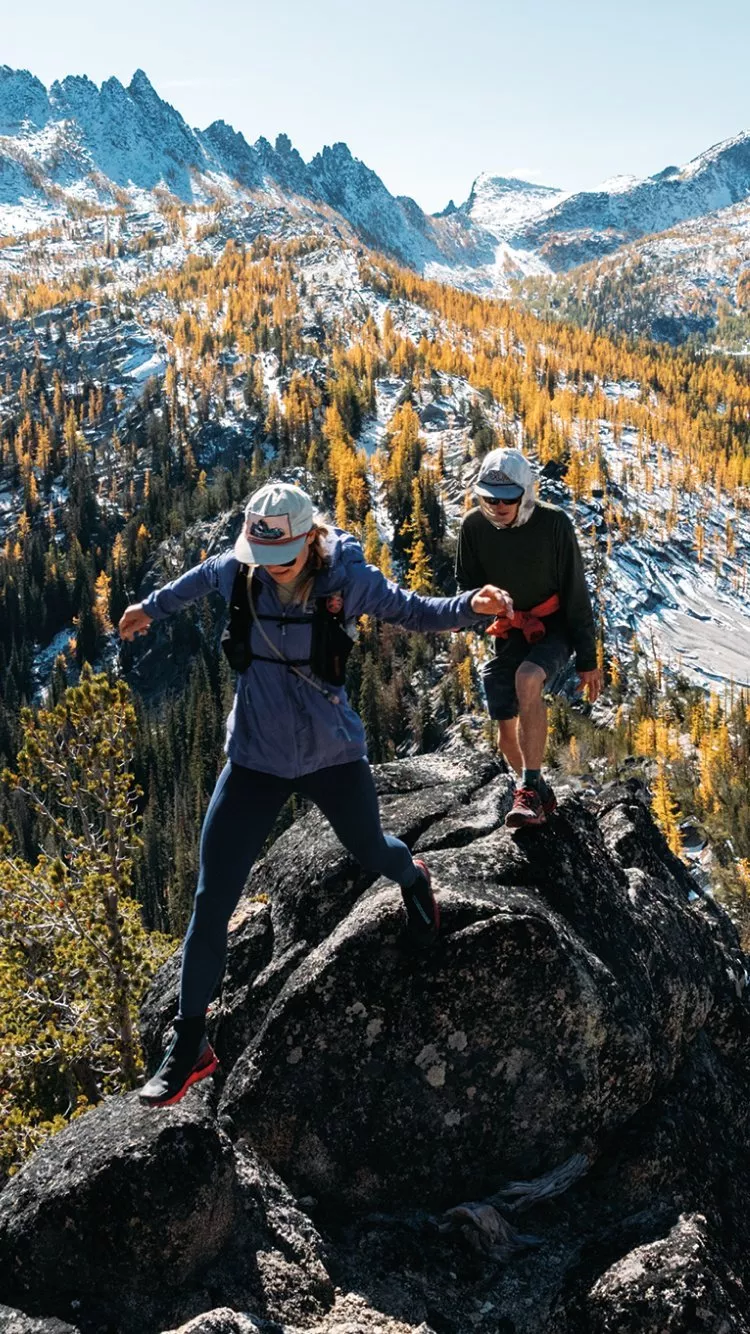 2 people hiking with a beautiful mountain view behind them