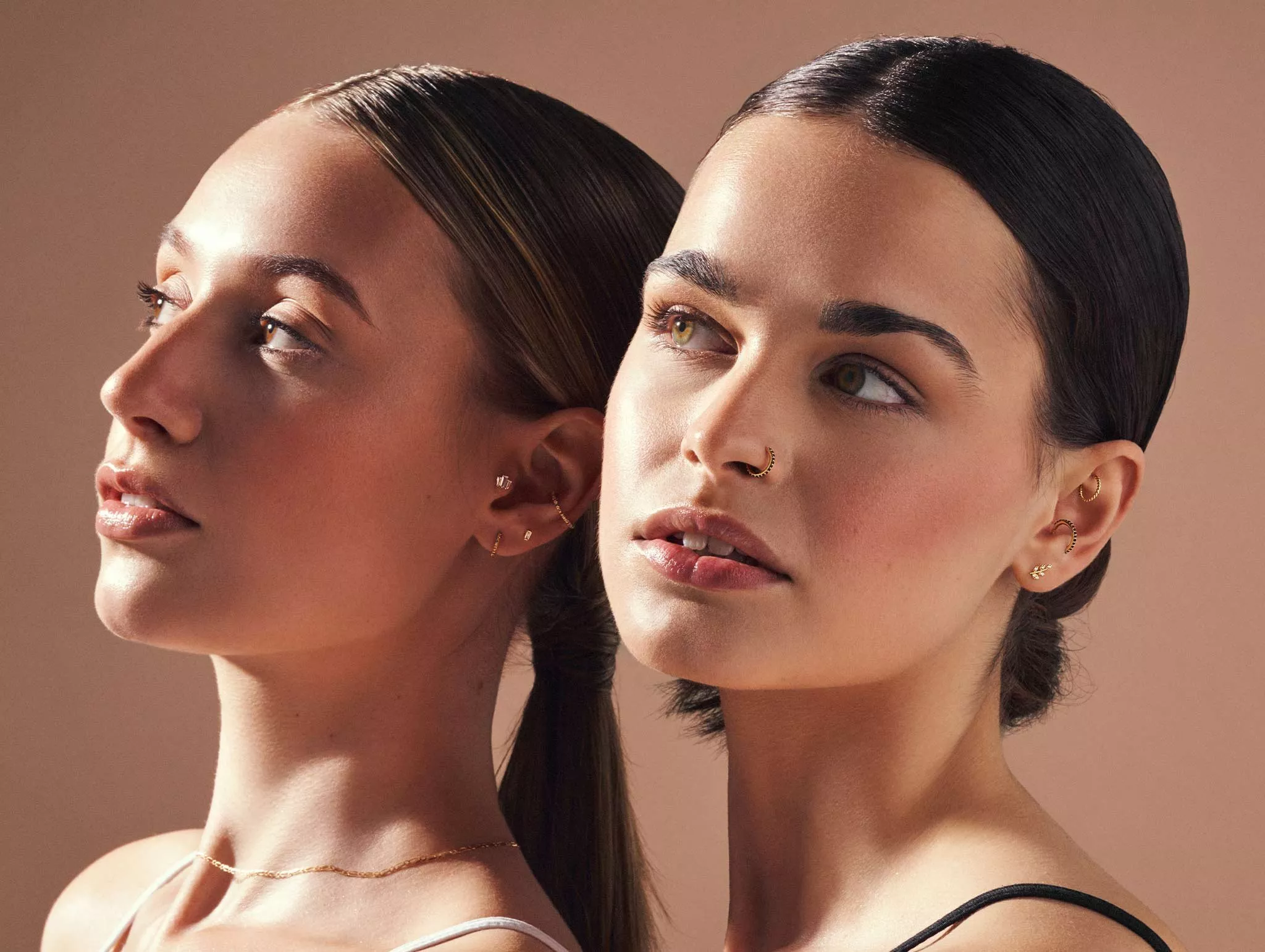 two women with nose and ear piercings