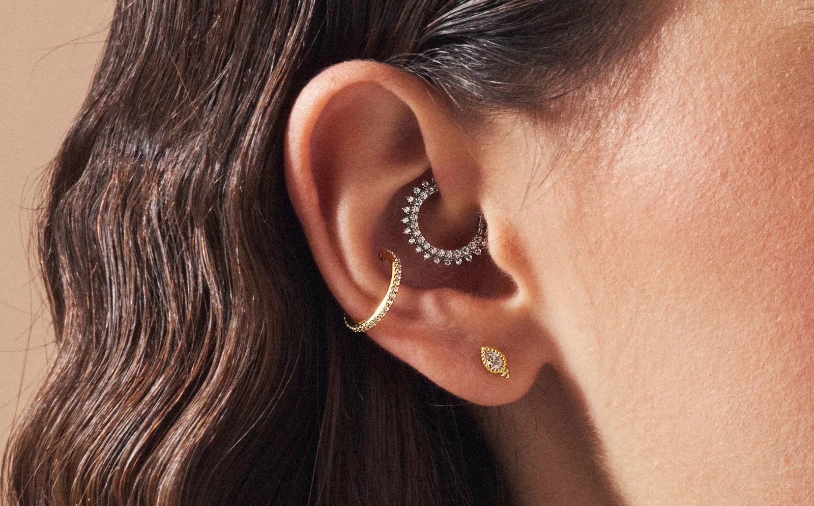 lady with 3 ear piercings in gold and silver