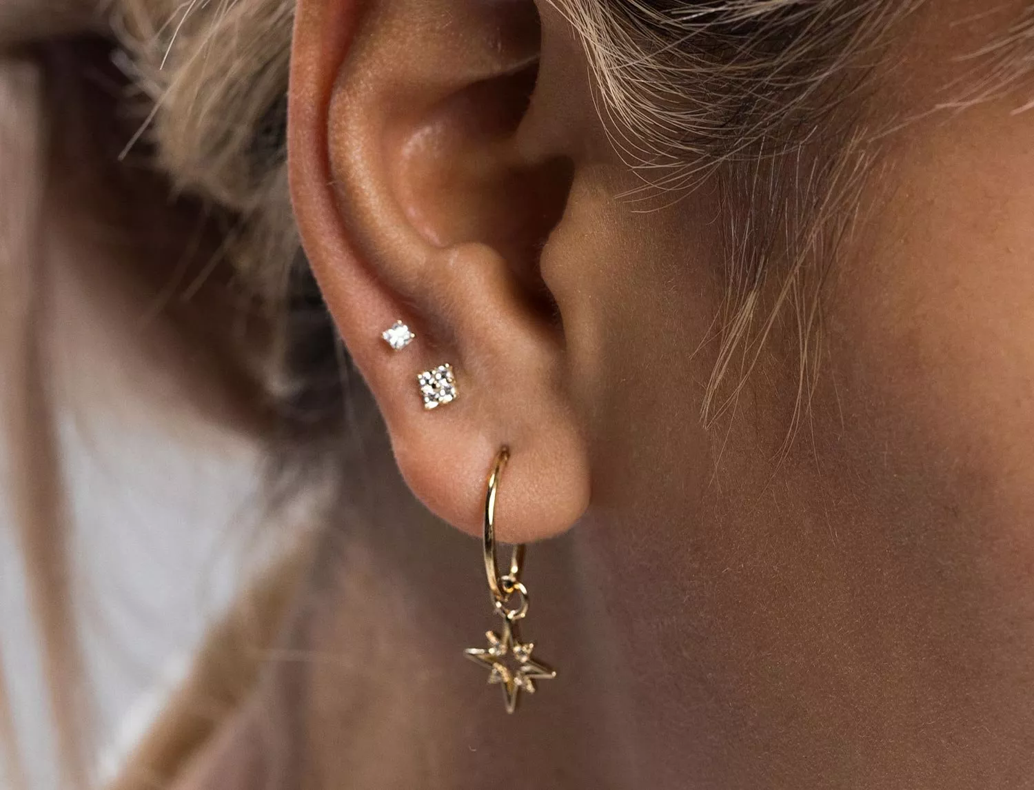 lady wearing three earrings 