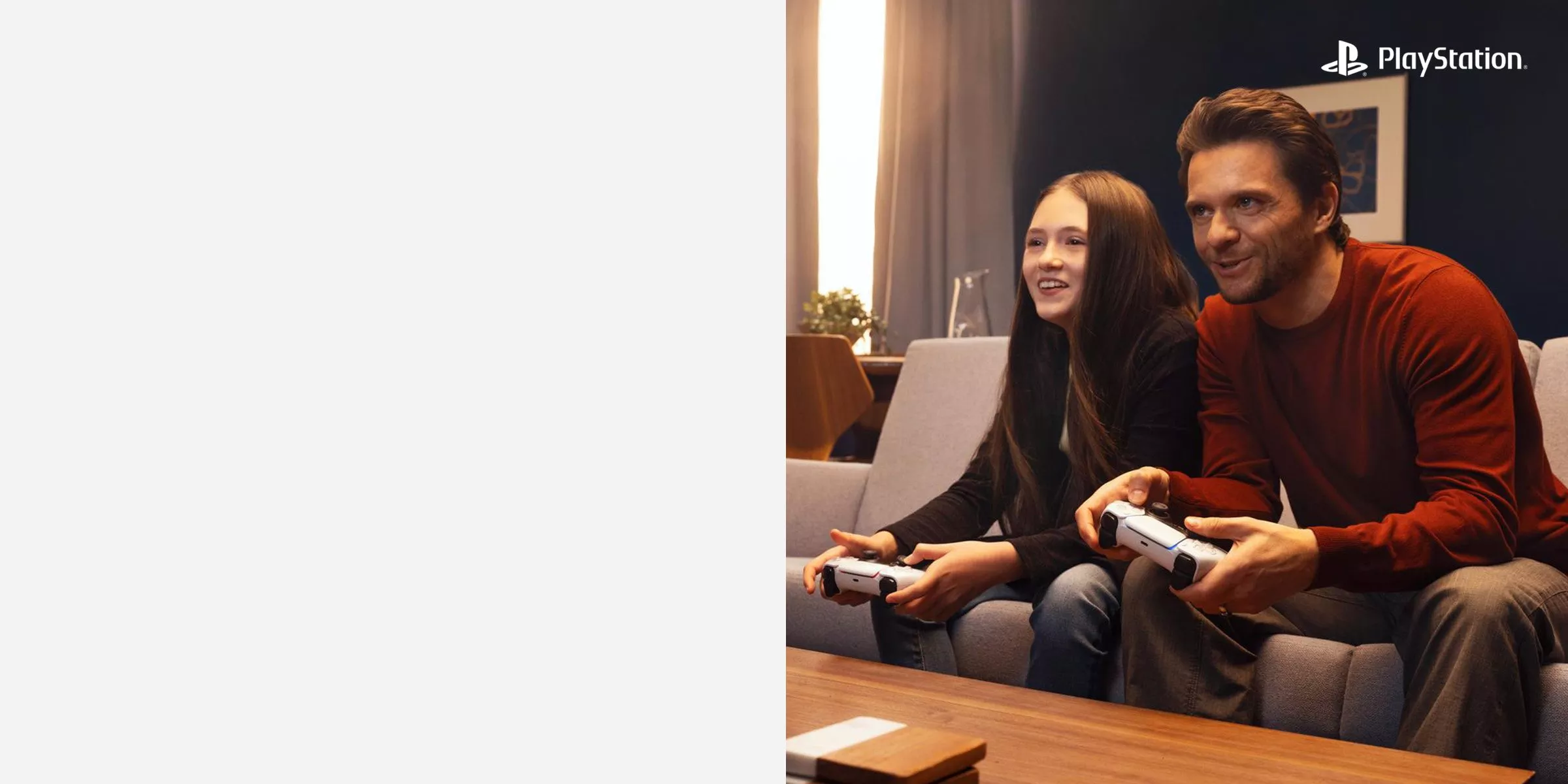 Two people sitting on the sofa with playstation controllers
