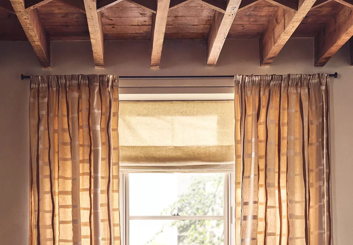 Window with beige curtains and cream roman blind