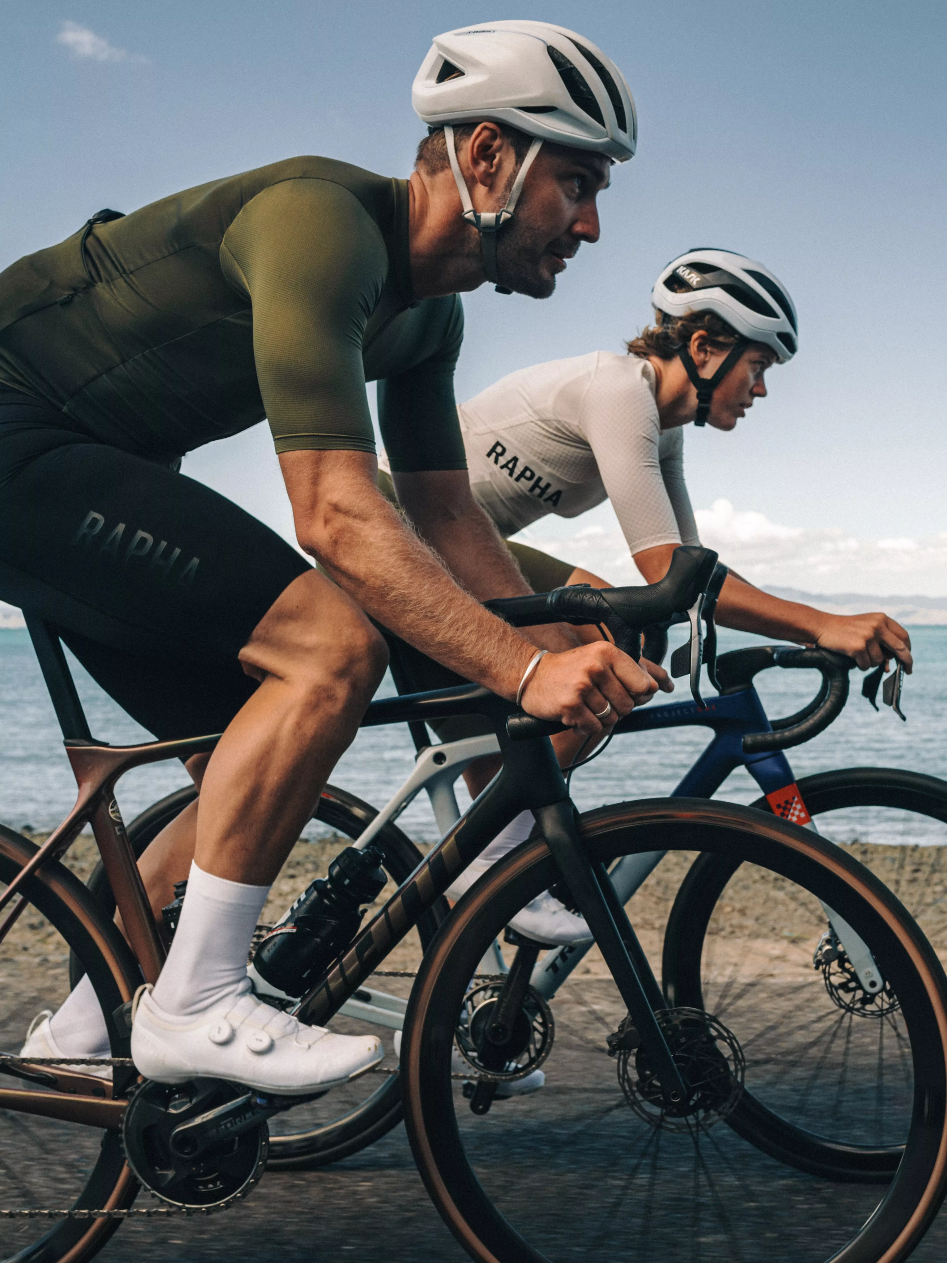 A man and woman cycling wearing Rapha clothing
