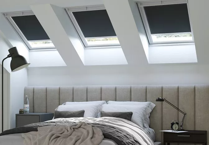 Velux windows with blinds on them over a bed