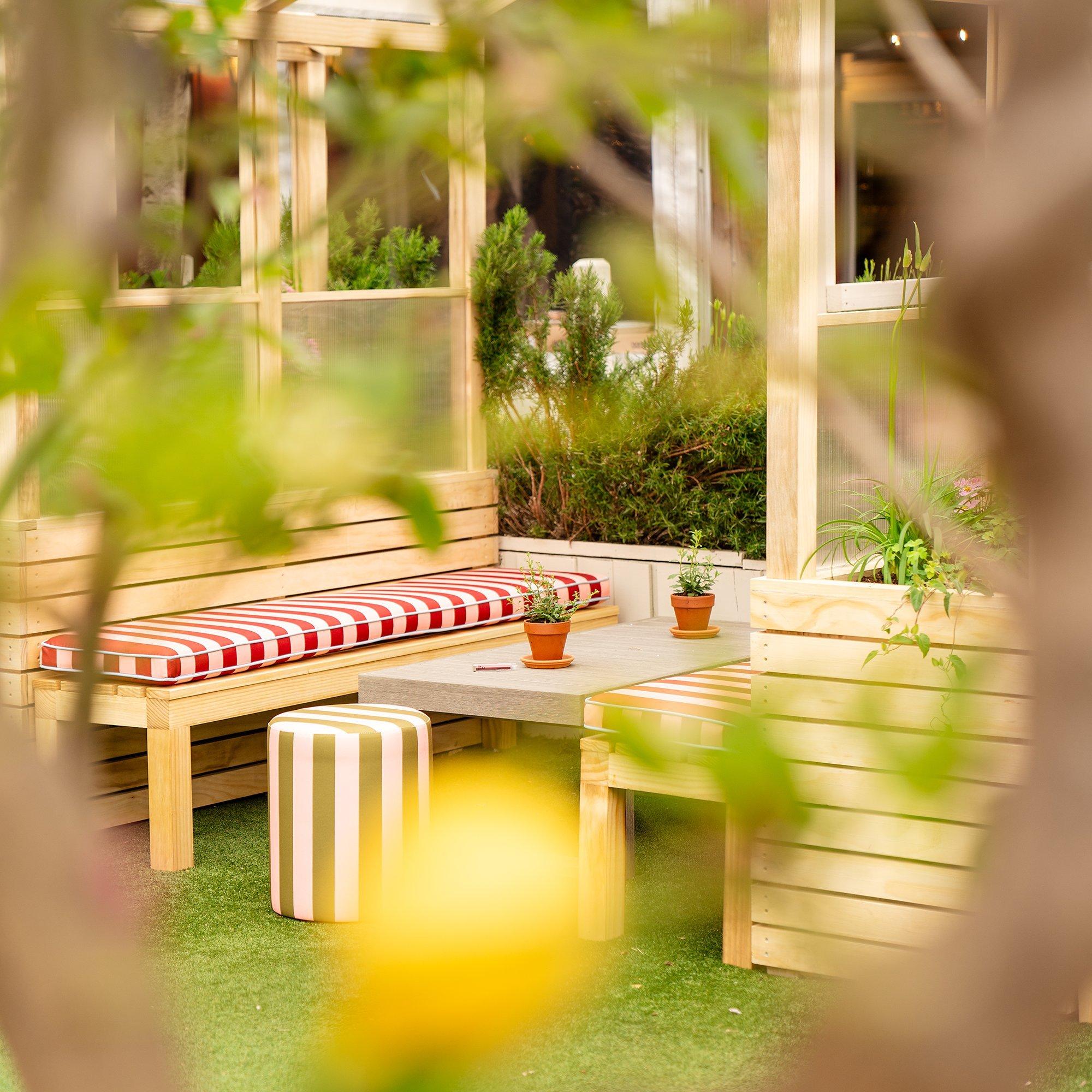 Image of a seated booth shot through some trees