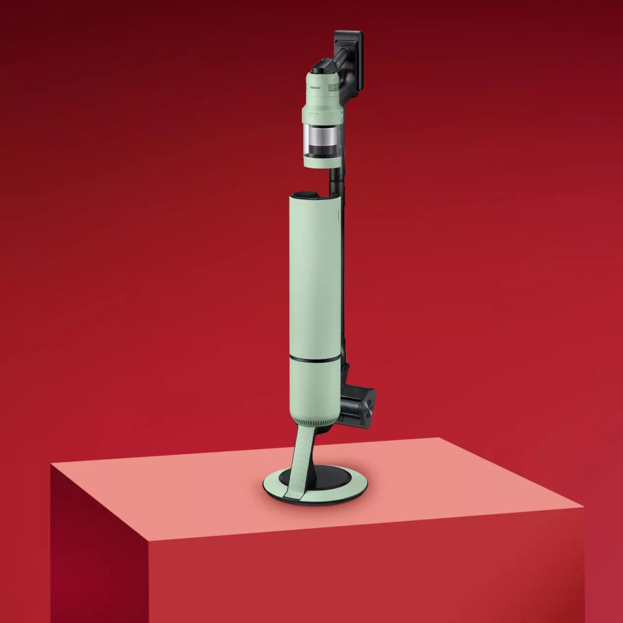 Green vacuum cleaner on a red background