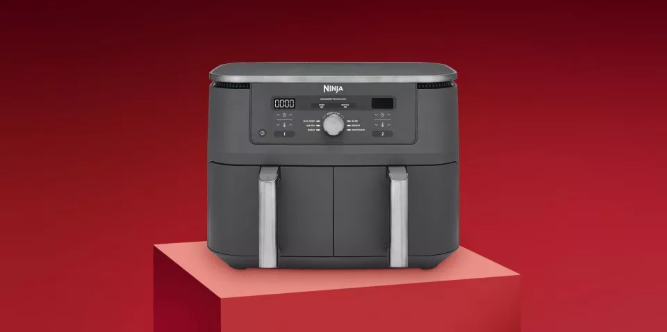 Black air fryer on a red background