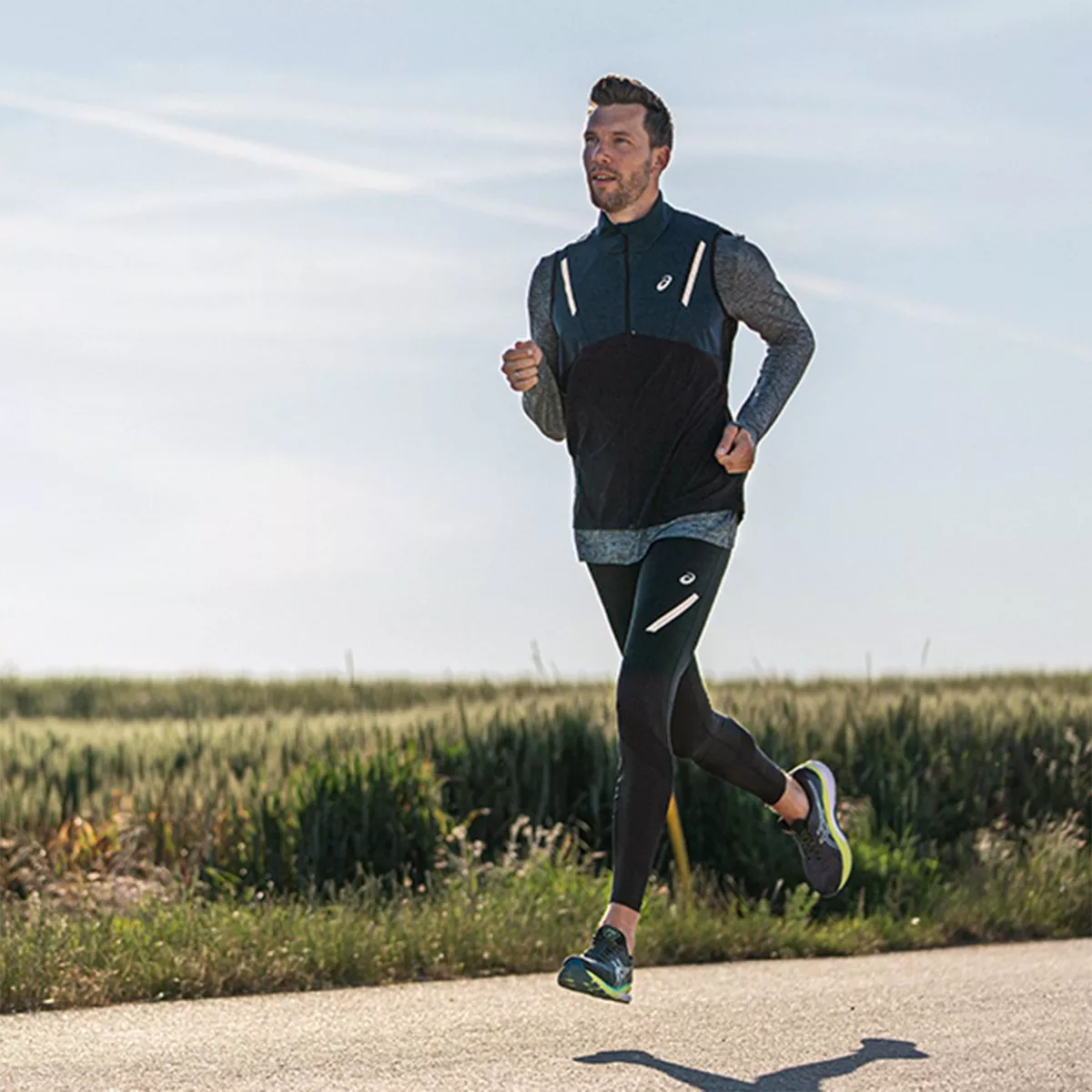 man running on a road wearing running apparel