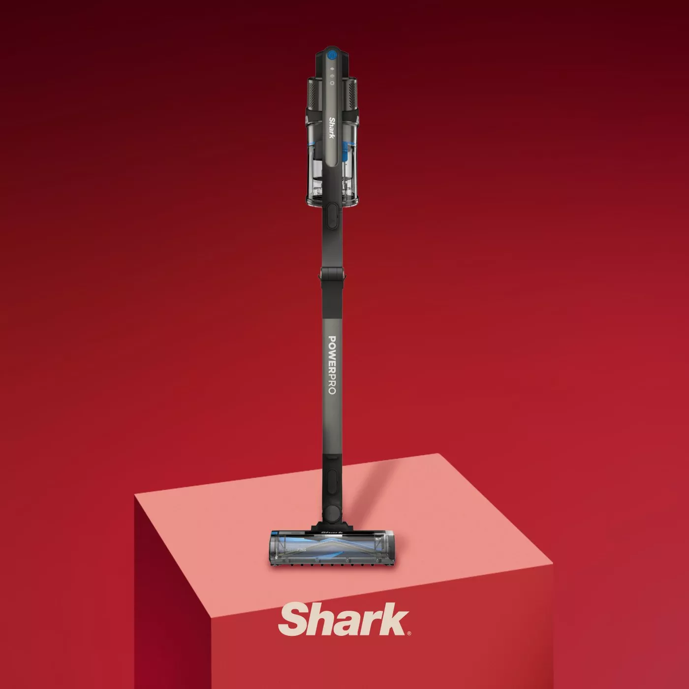 Shark PowerPro cordless stick vacuum cleaner on red podium, modern upright hoover product shot on red backdrop