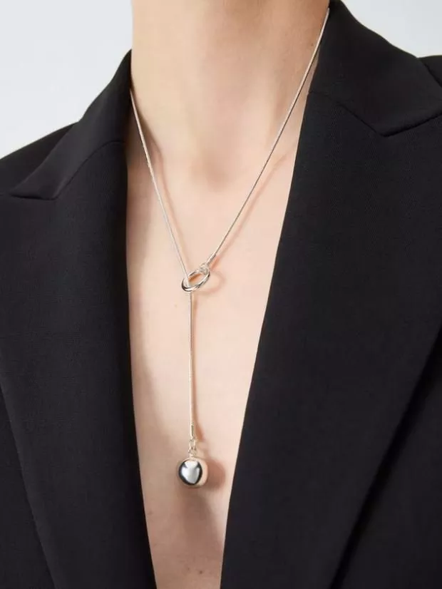 woman wearing silver drop pendant necklace