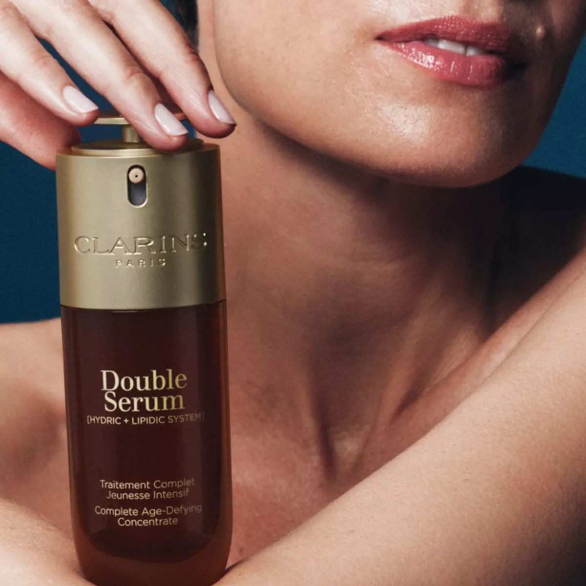 close up of woman holding a Clarins serum product
