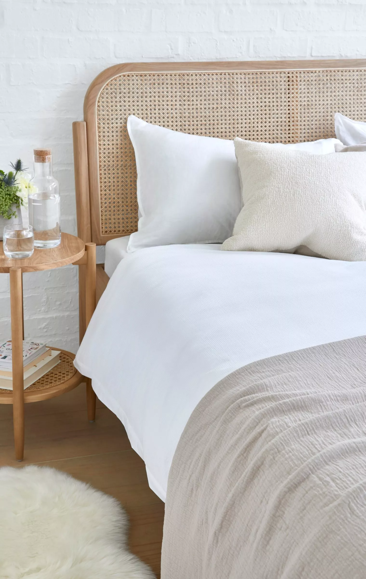 Mattress on a bed with pillows on and throw 