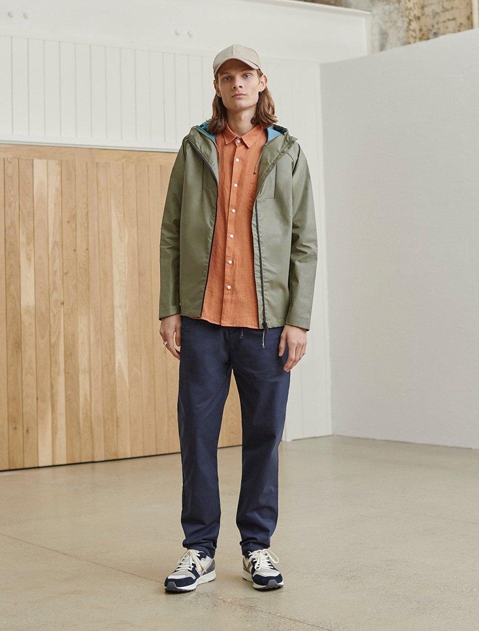 Model in khaki jacket and orange shirt