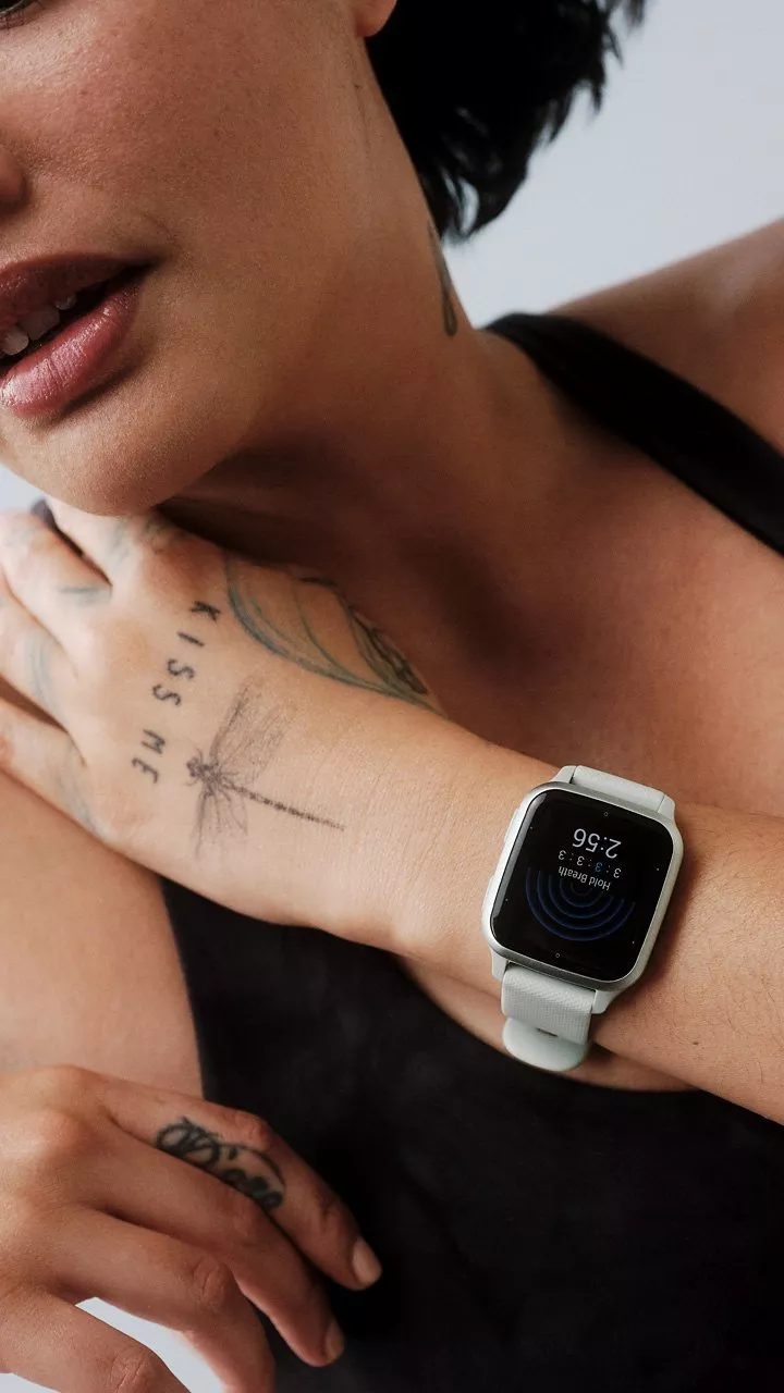 close up of a person wearing a white smartwatch showing heart rate, fitness tracking on wrist