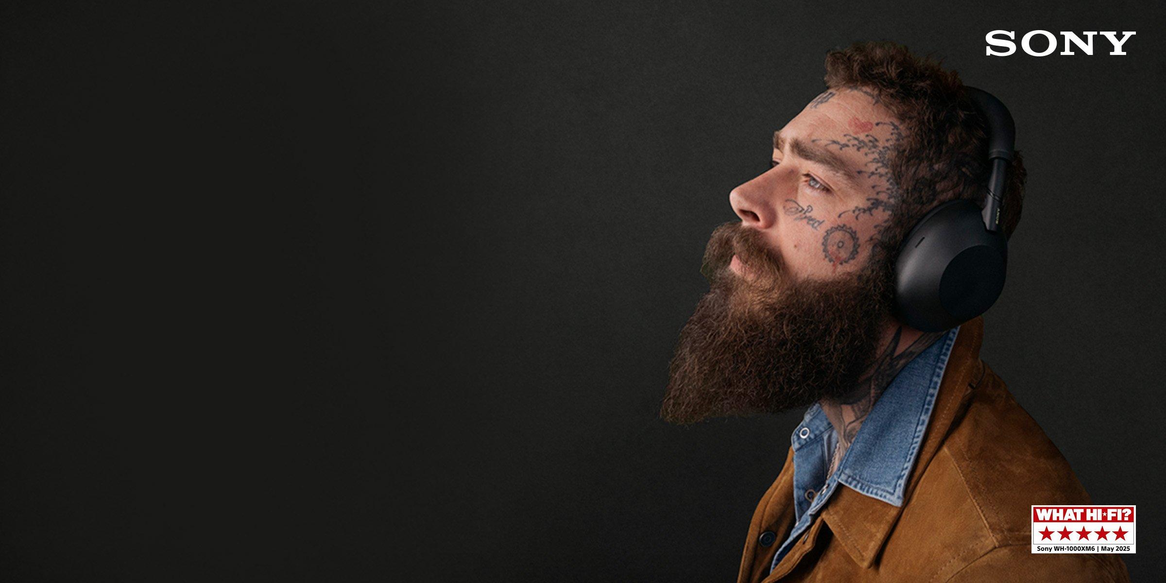 Post malone american singer and rapper wearing sony headphones, facing left, against a dark background.