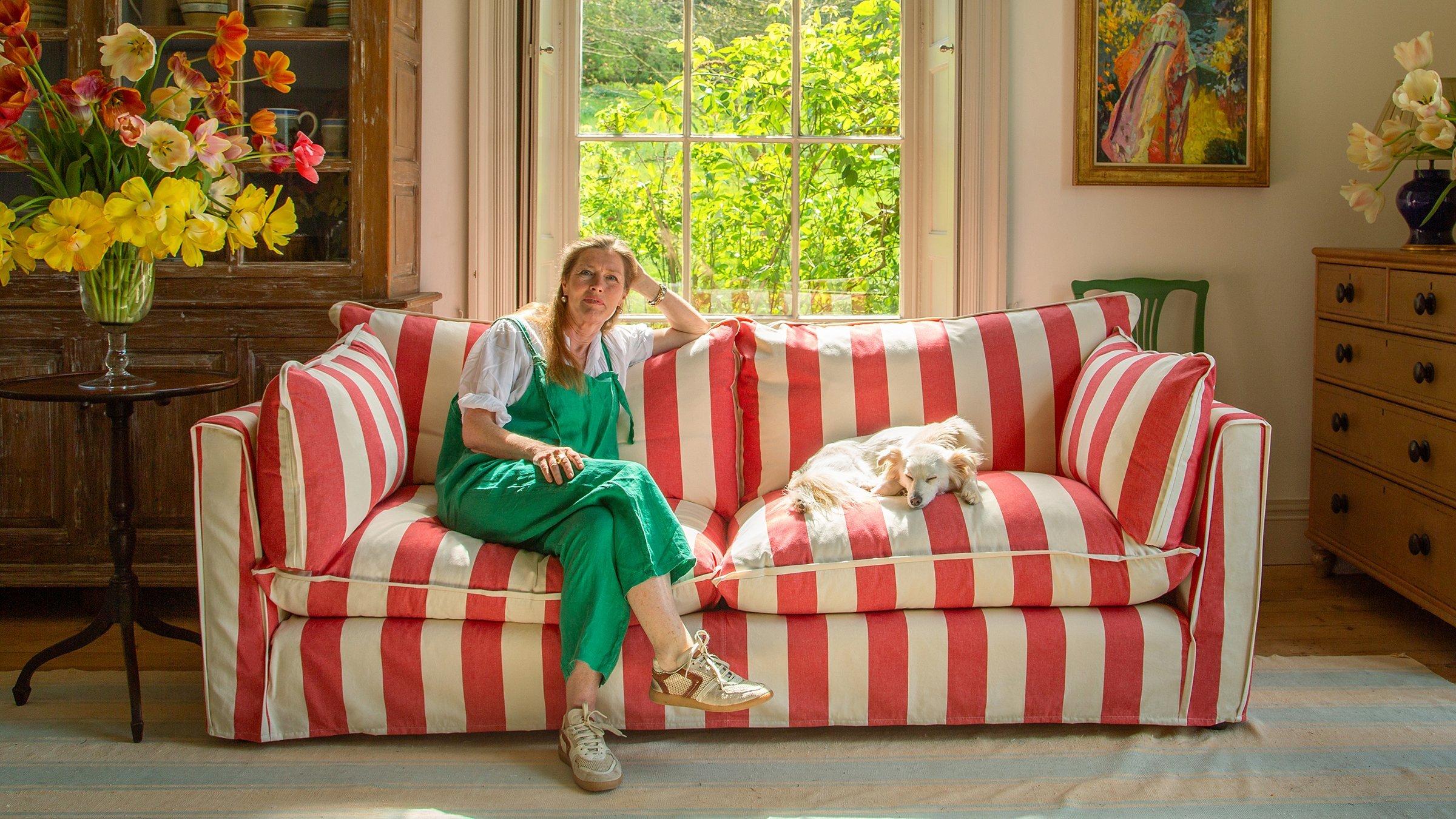 Sophie Conran sat on a striped white and red sofa with a dog