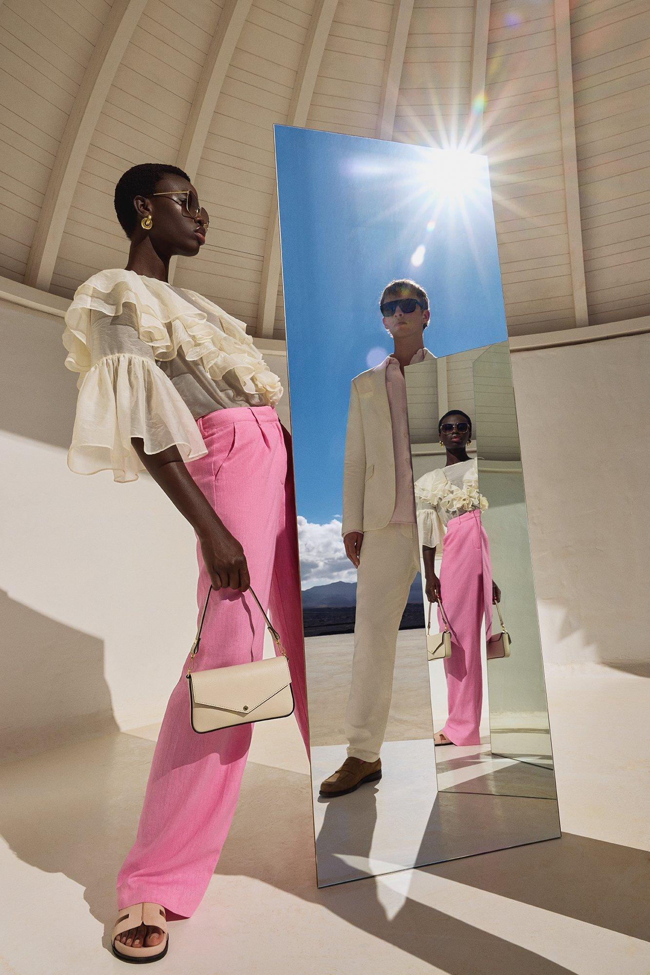 Image of a female model holding a mirror with a reflection of a male model holding a mirror relfecting her reflection