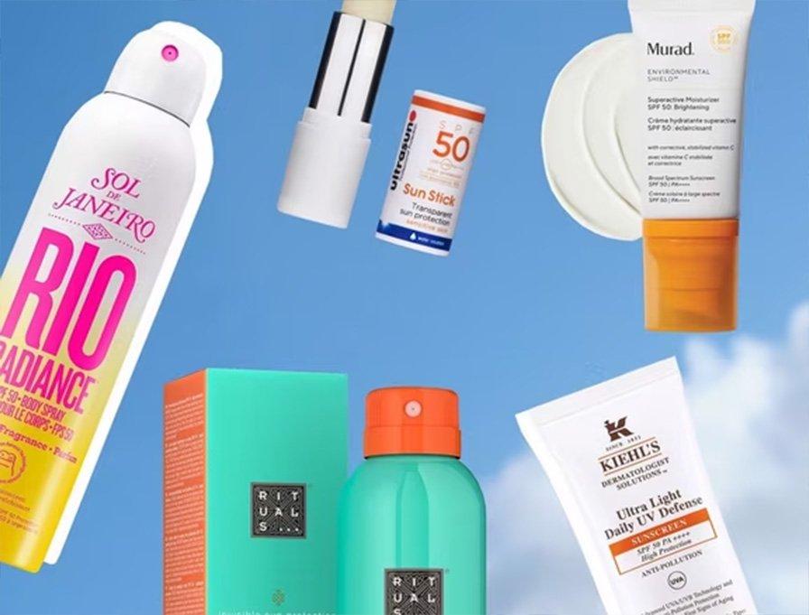 Assorted skincare and sunscreen products against a blue sky background.