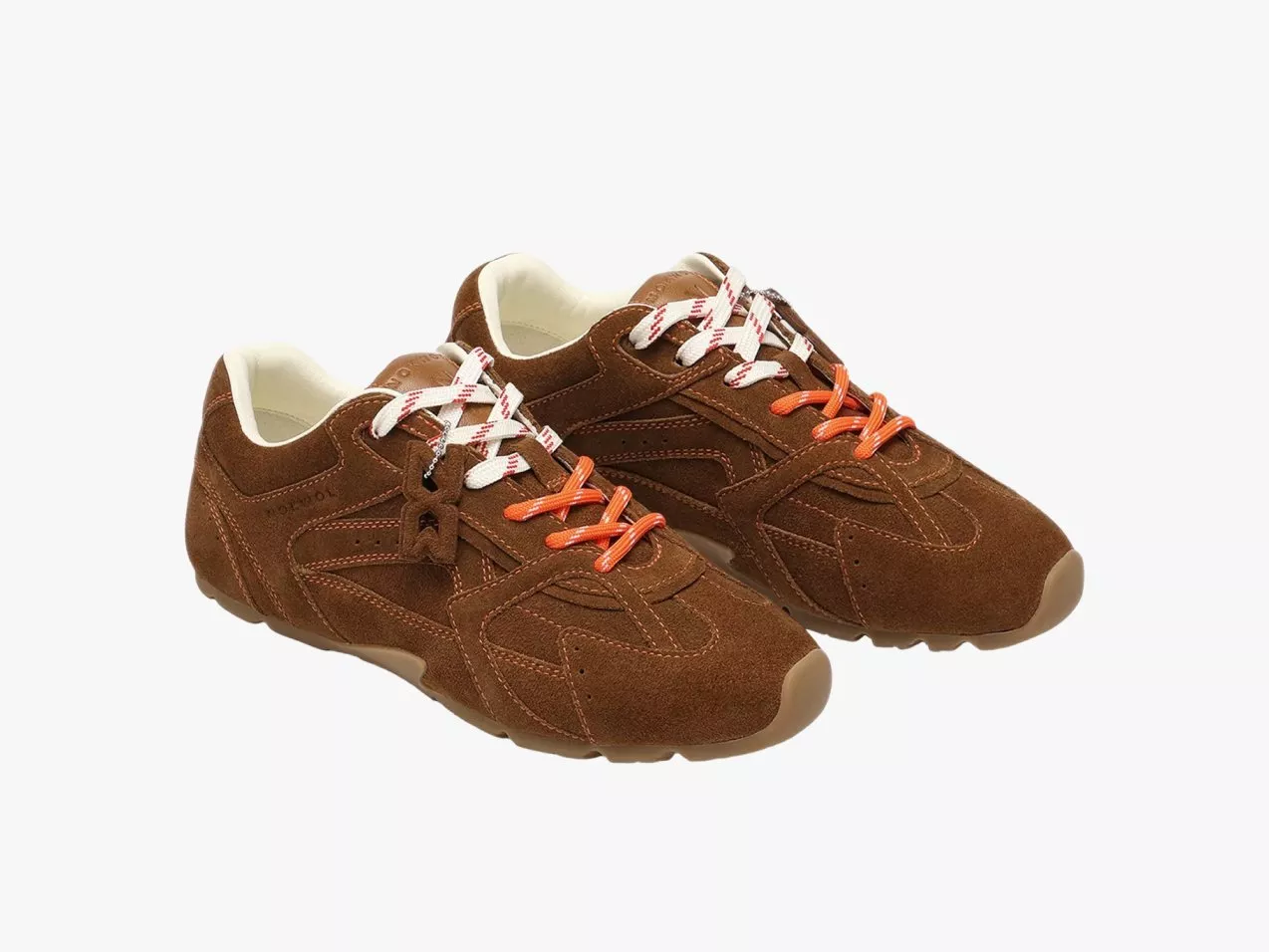 Pair of brown suede trainers with orange and white laces, low-profile casual shoes on white background
