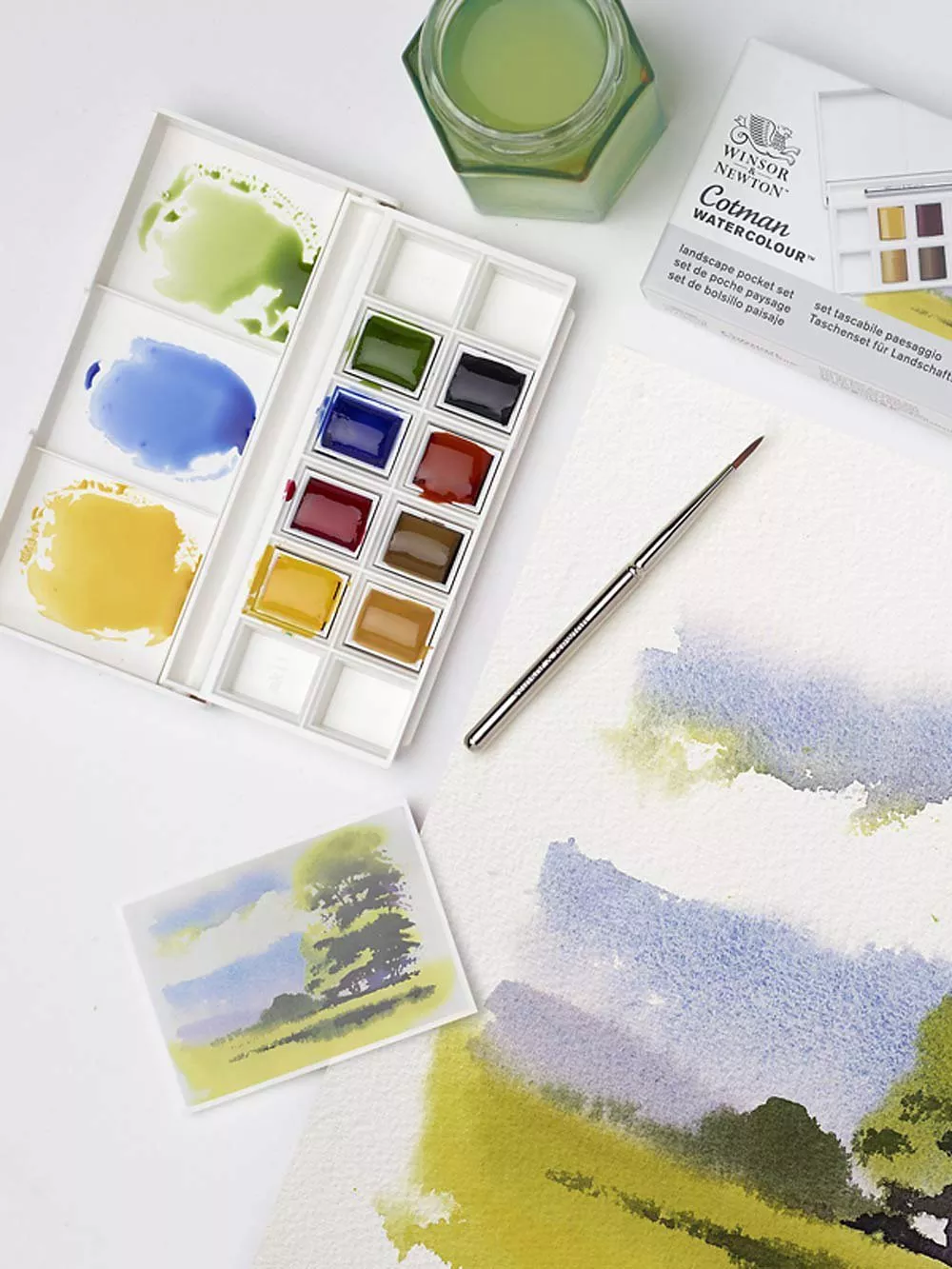 Watercolour paint pallet next to painting