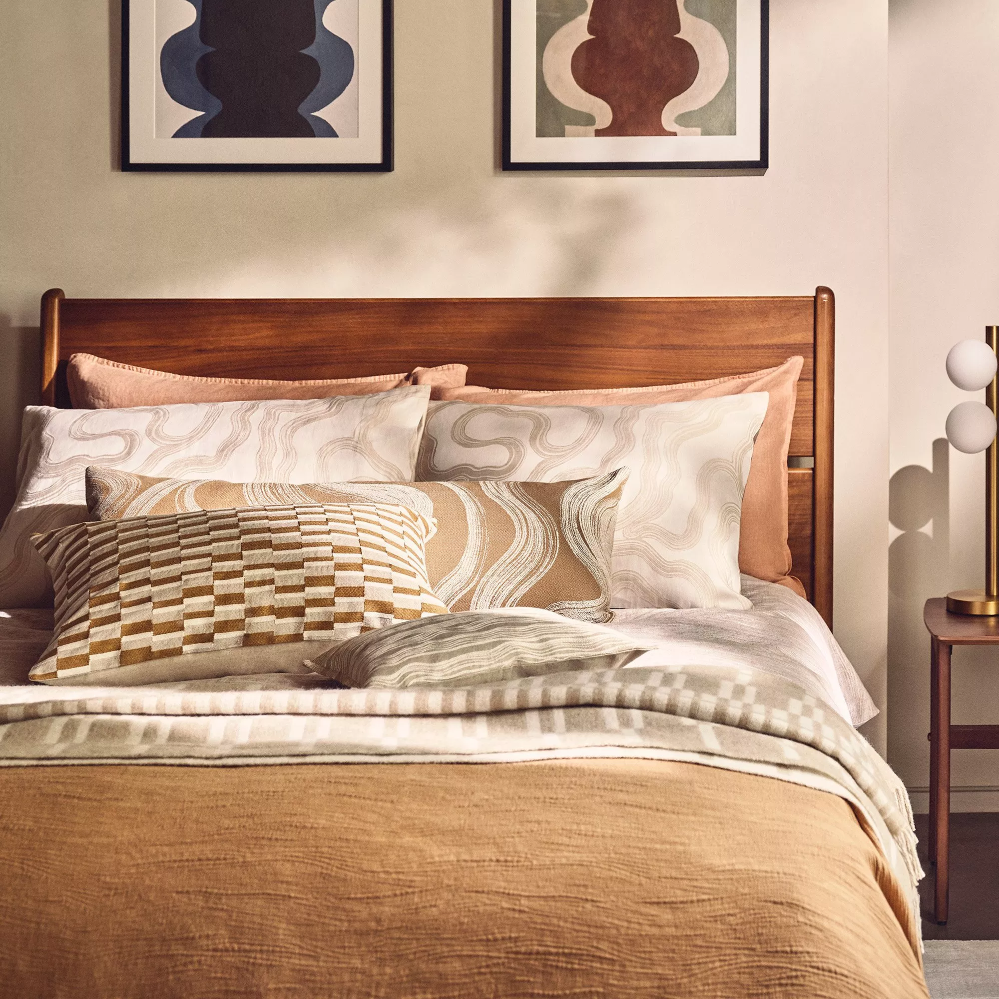 Wooden bedframe with neutral bedding and cushions