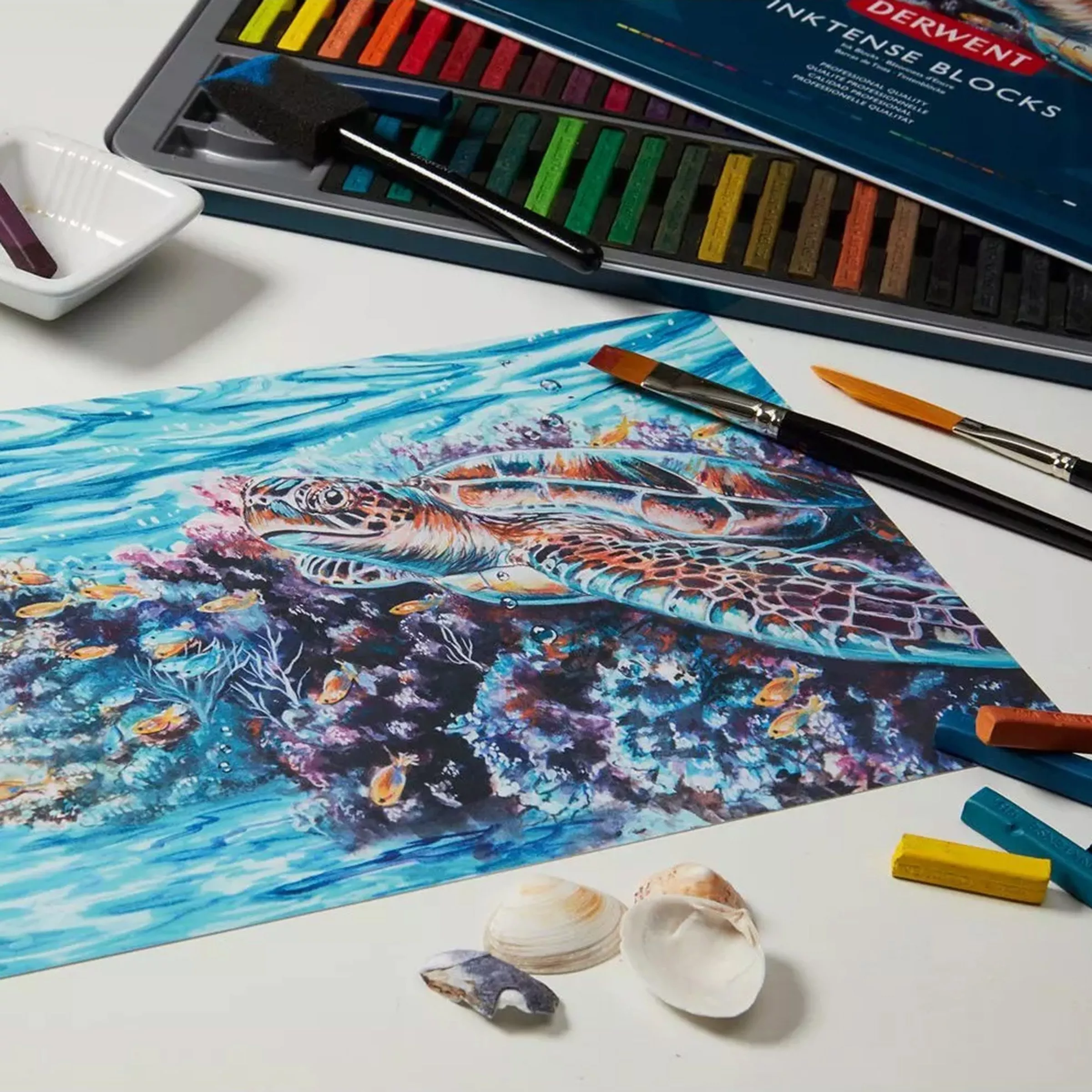 Watercolour paint pallet next to painting