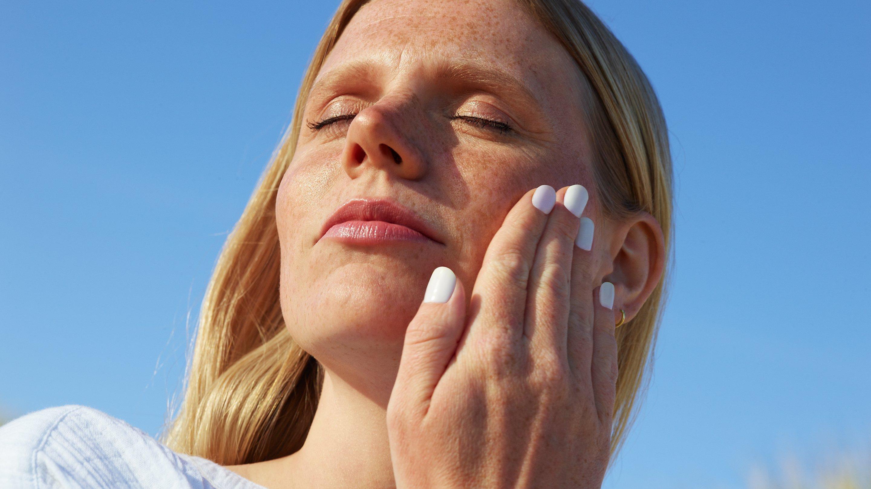 Staycation - lady applying sun lotion onto skin with hand