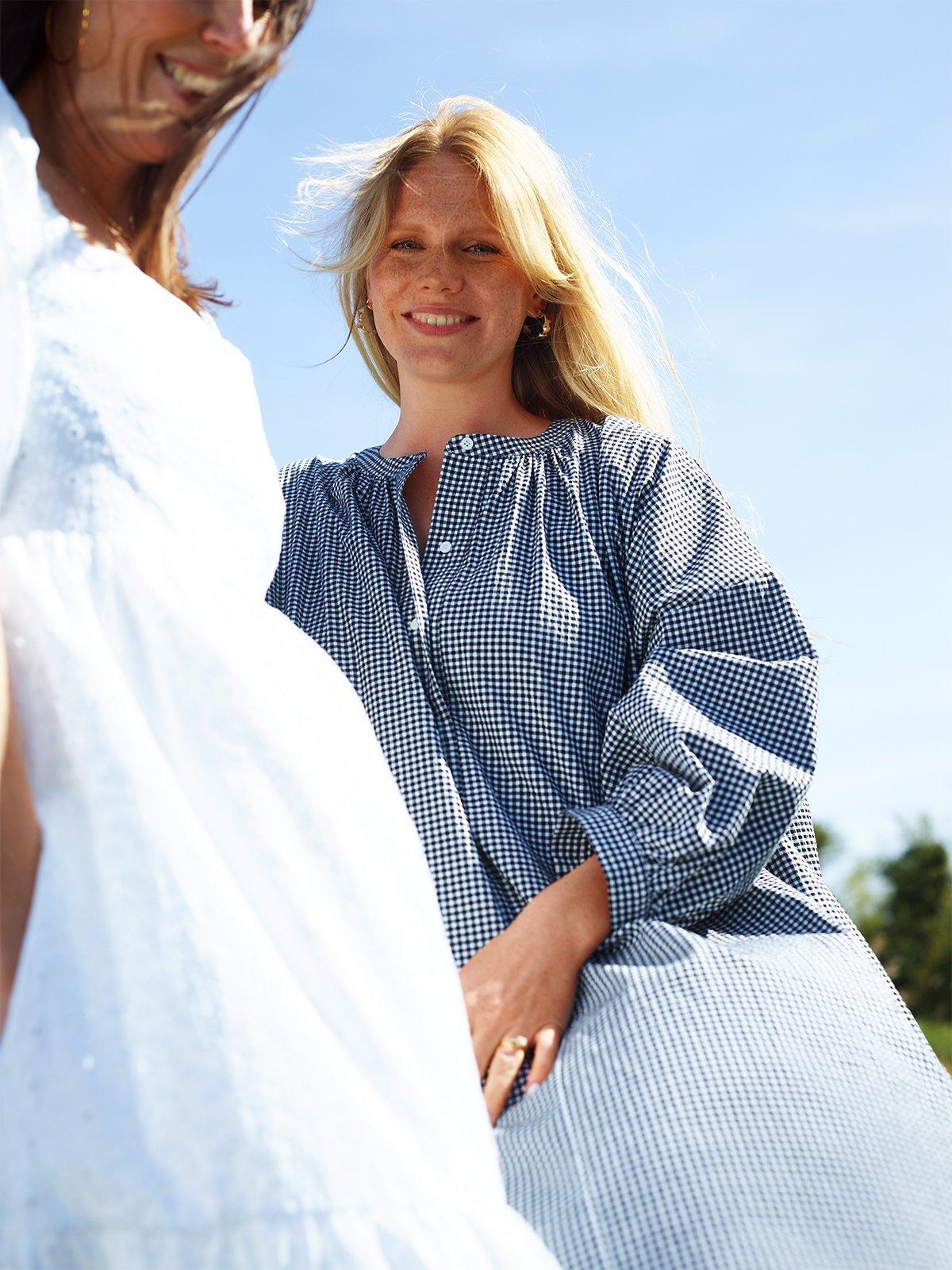 Staycation - Lady in blue checked dress, lady in white dress