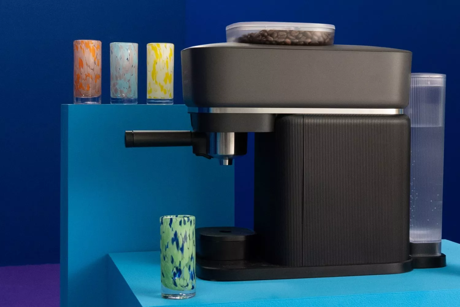 Modern Philips Barista coffee machine, styled with colourful speckled glasses on blue set