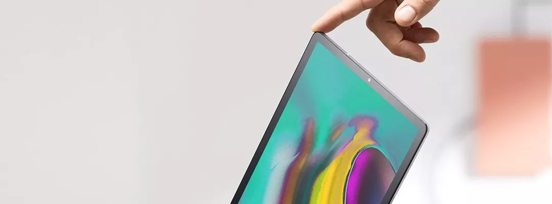 A Tablet tilted on it's side with a hand holding it up