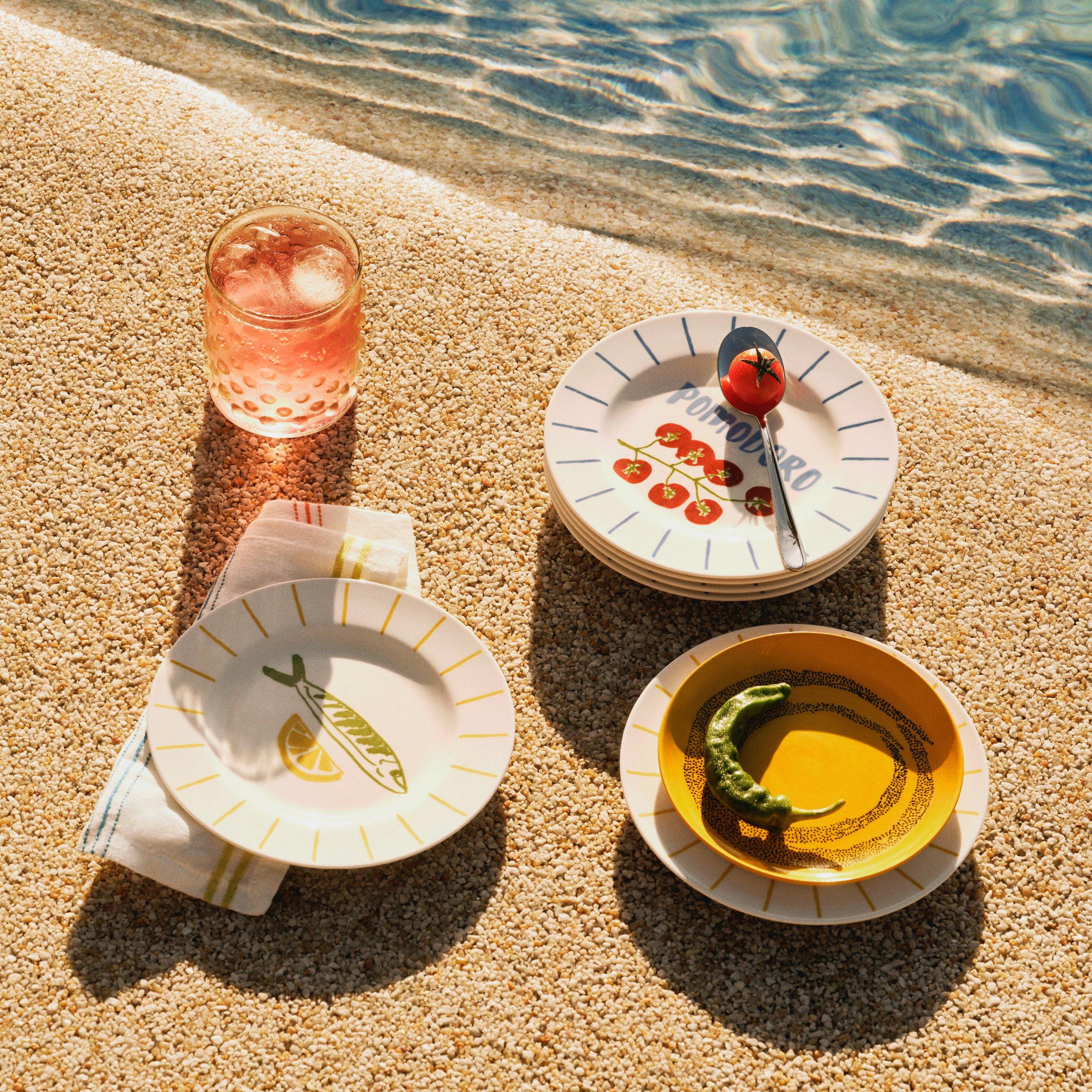 outdoor plates and bowls on a pool edge.