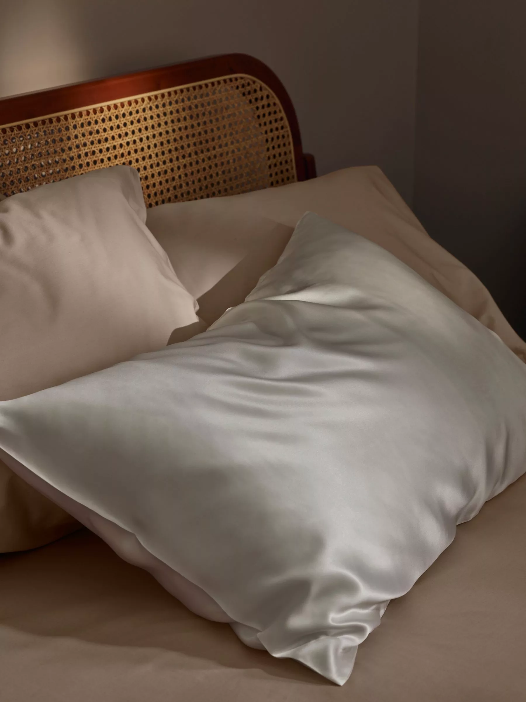 White silk pillow against pink pillows
