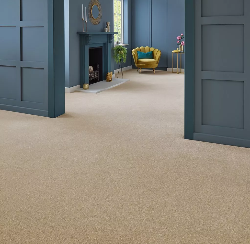 Elegant room with beige carpet, blue panelled walls, and stylish decor including a yellow chair and fireplace.