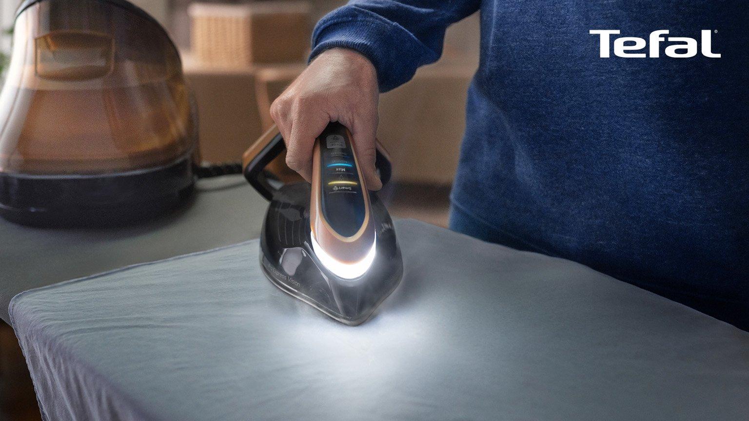 tefal iron pro in hand with light on table