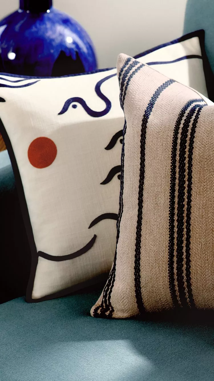 Living room with teal sofa, wooden coffee table, and hanging ceiling light with sculptural lampshade