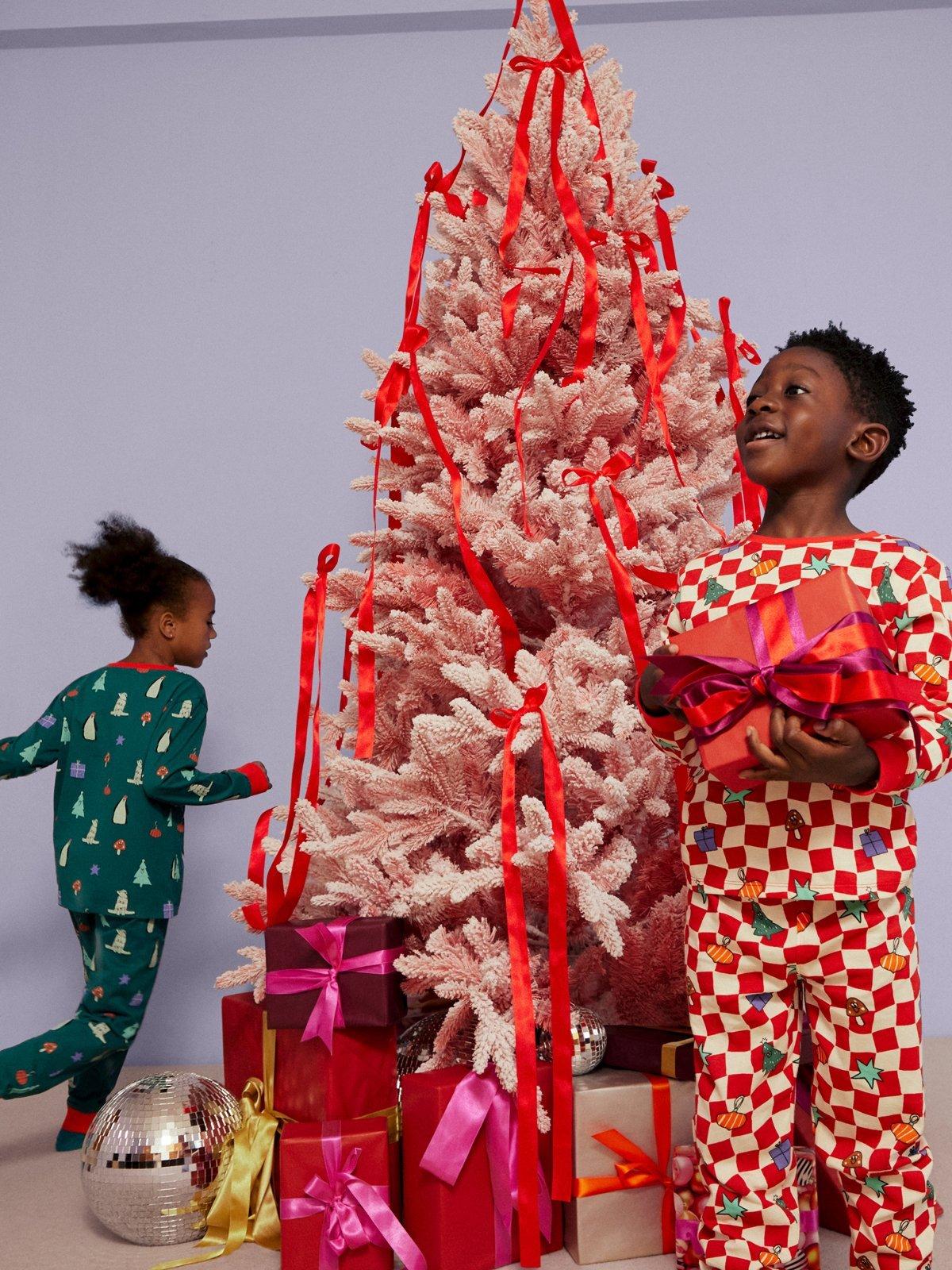 image of kids in pyjamas running round a Christmas tree