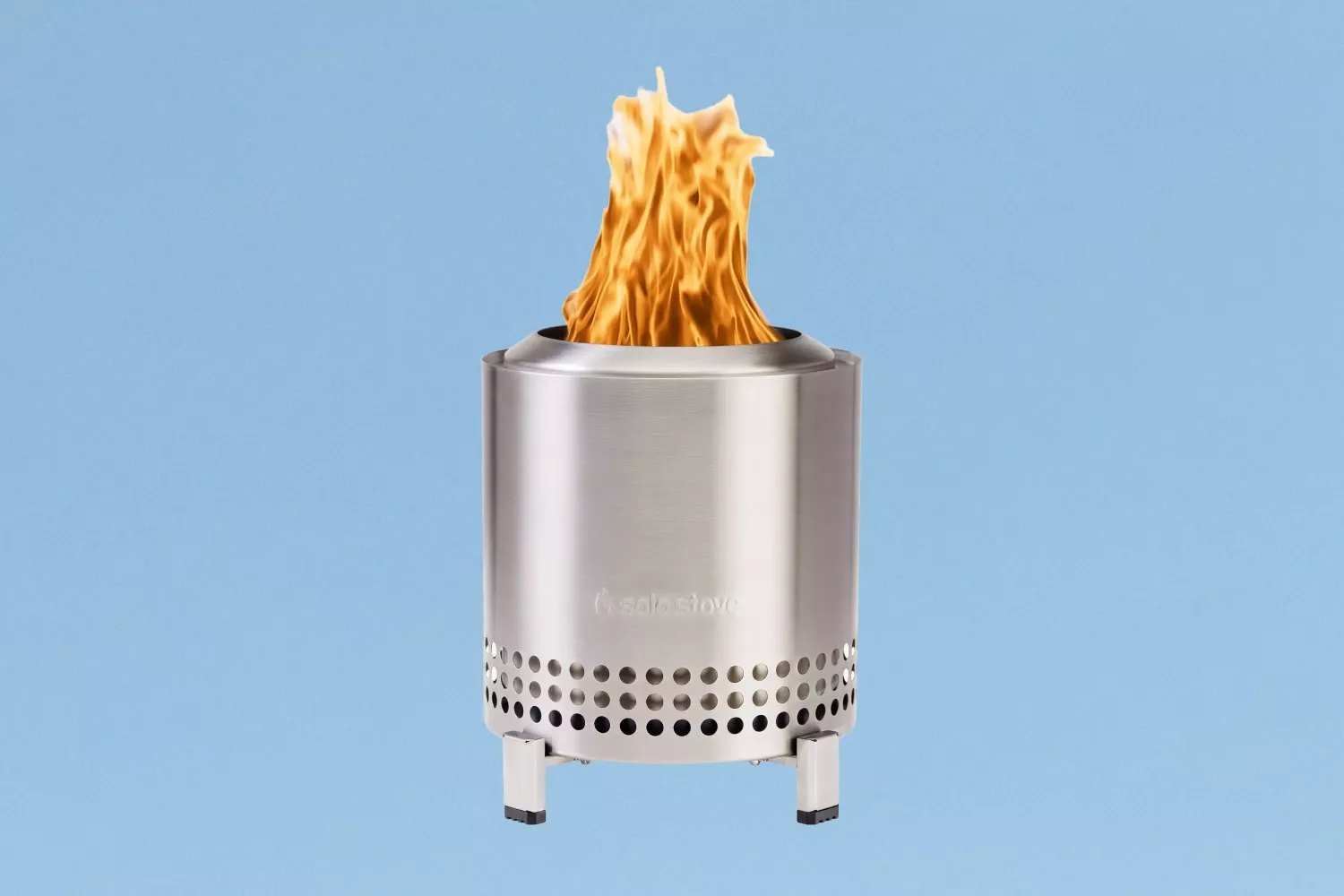Stainless steel smokeless fire pit with tall flame, portable outdoor camping stove on blue background