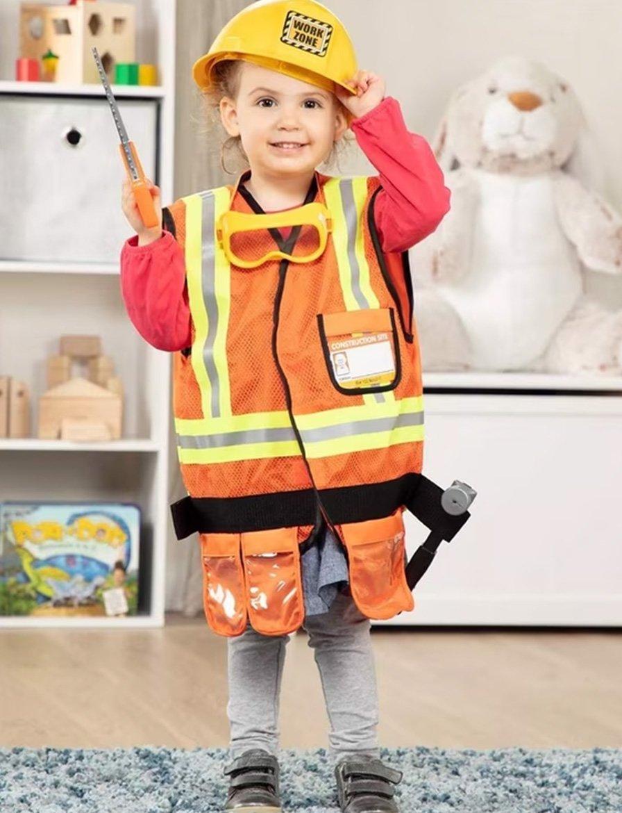 A young child dressed in a construction worker outfit, complete with a helmet, safety vest, and goggles, holding a tool