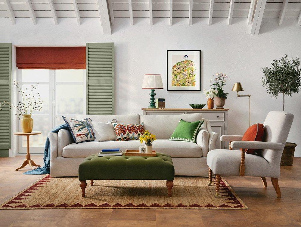 Living room with white sofas and large padded green footstool