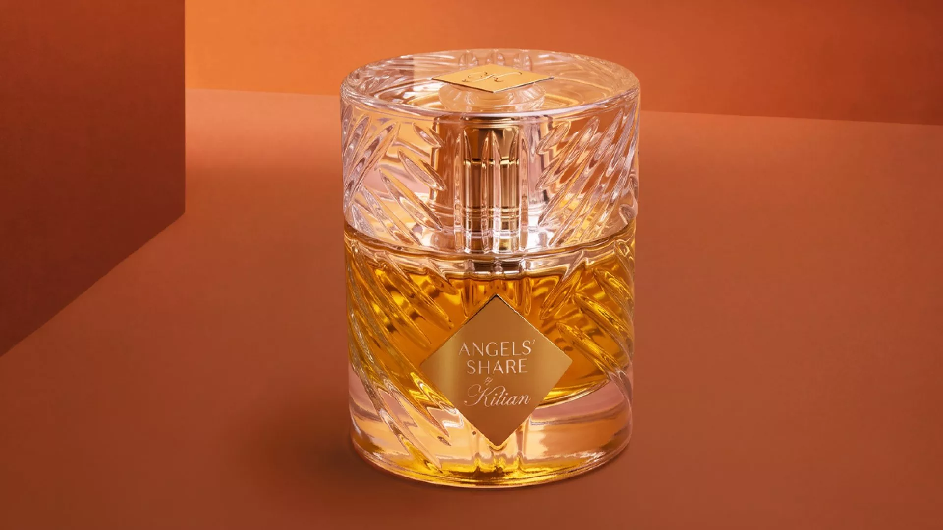 Kilian Angels’ Share perfume bottle with amber fragrance in cut-glass flacon on warm brown studio background