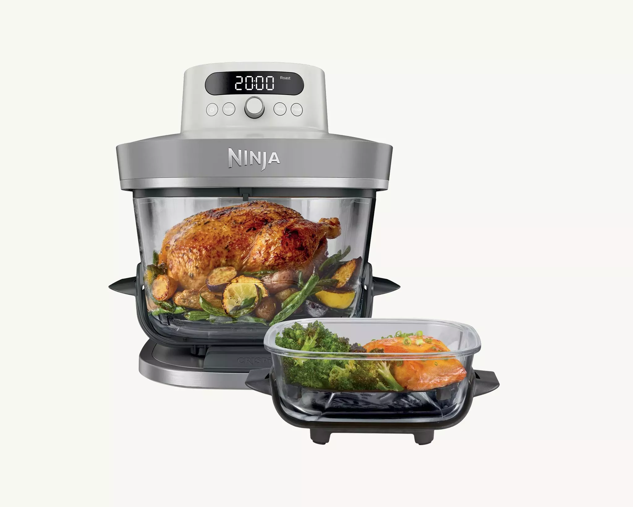 Ninja air fryer oven with glass bowl roasting whole chicken and vegetables, plus tray with salmon and broccoli