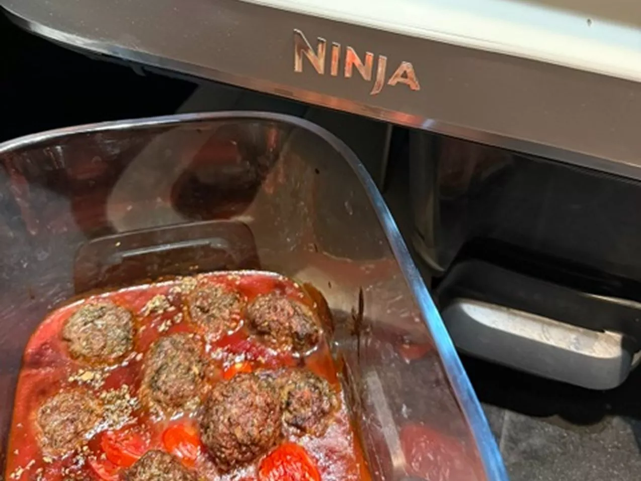 Tomato meatballs in a glass dish next to a Ninja Airfryer