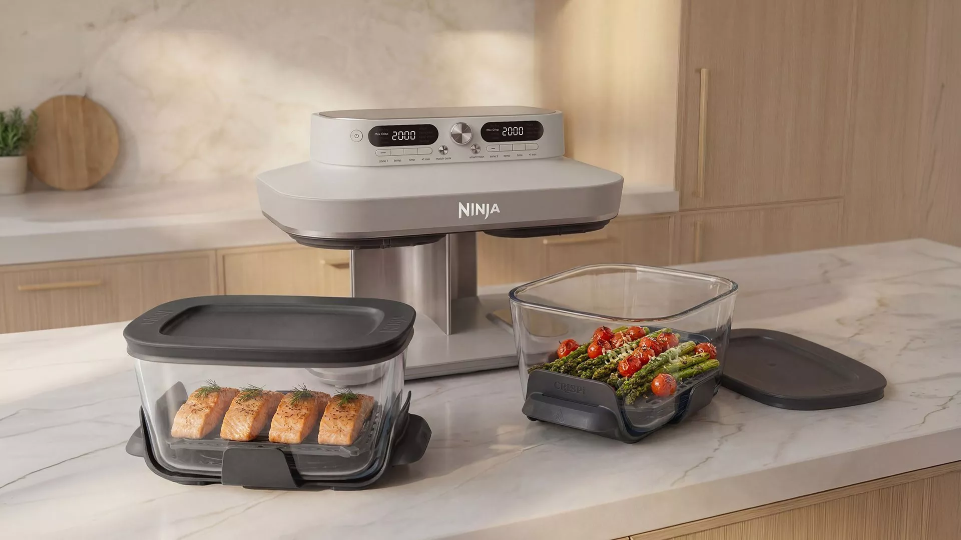 Ninja dual zone air fryer with glass containers, cooking salmon fillets and asparagus with tomatoes on worktop
