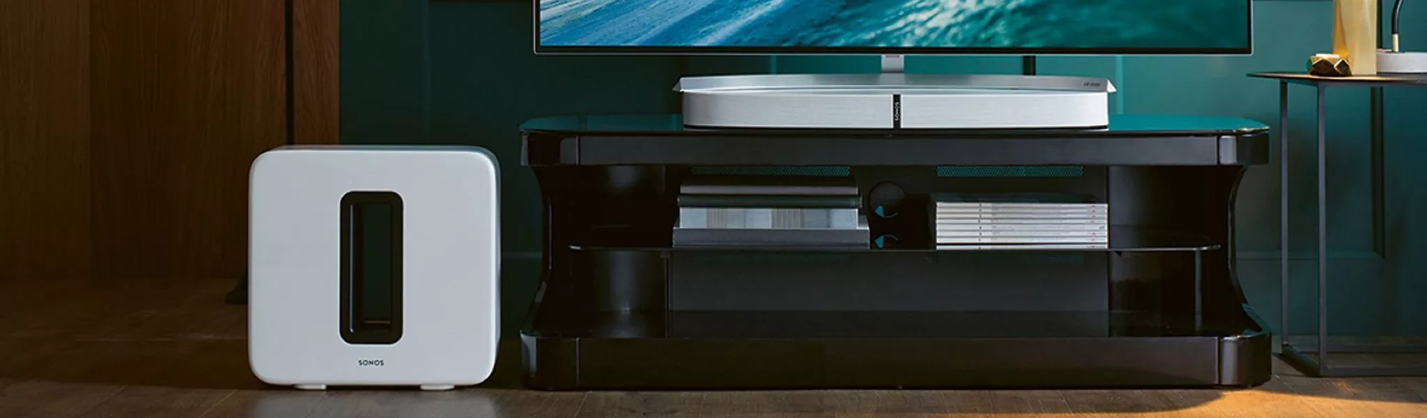 Modern entertainment setup with a white subwoofer and sleek black TV stand in a stylish living room setting.