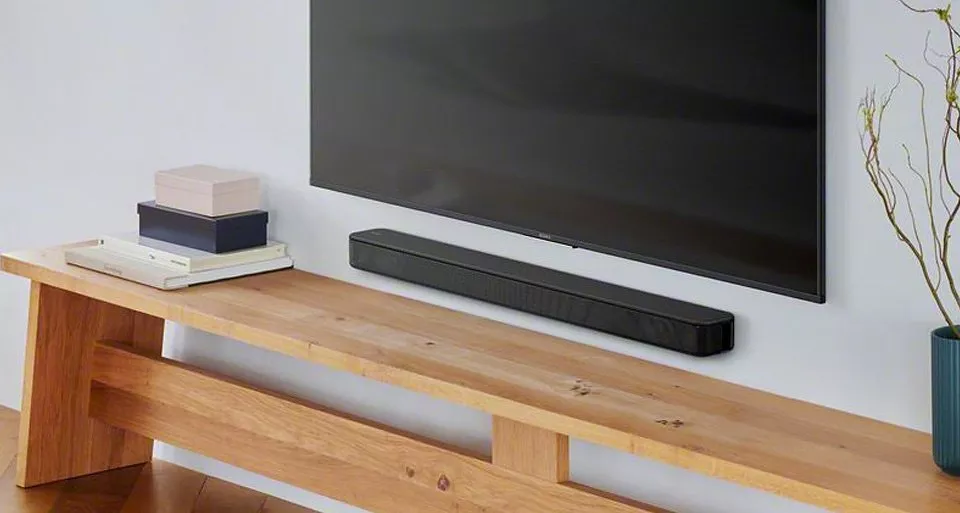 TV attached to the wall with a soundbar beneath 