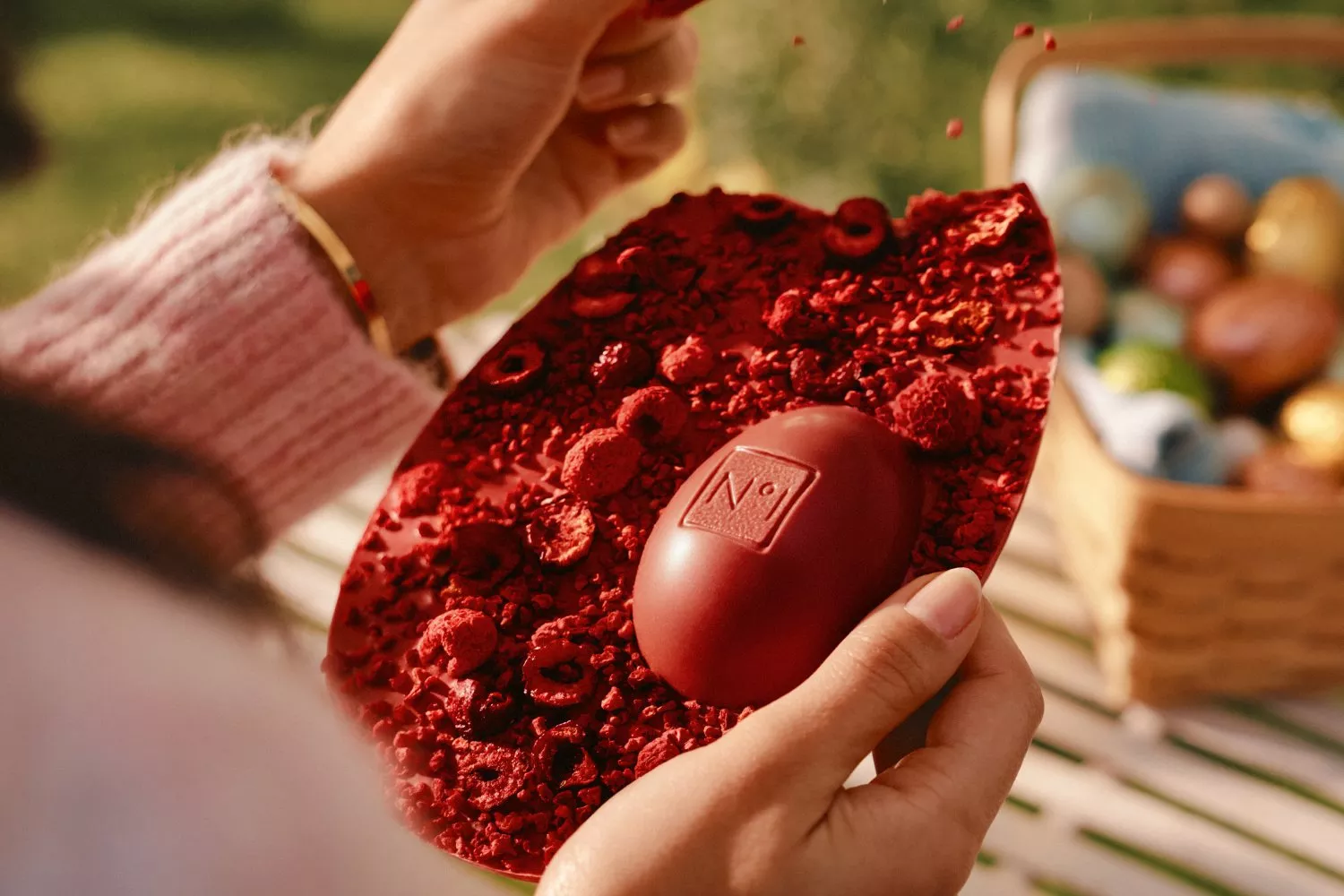 Easter-themed scene with a Waitrose dark chocolate orange egg and colourful candies on a table setting.