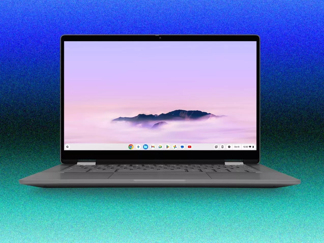 Grey Chromebook laptop open with Chrome OS desktop and mountain wallpaper on a blue-green gradient background