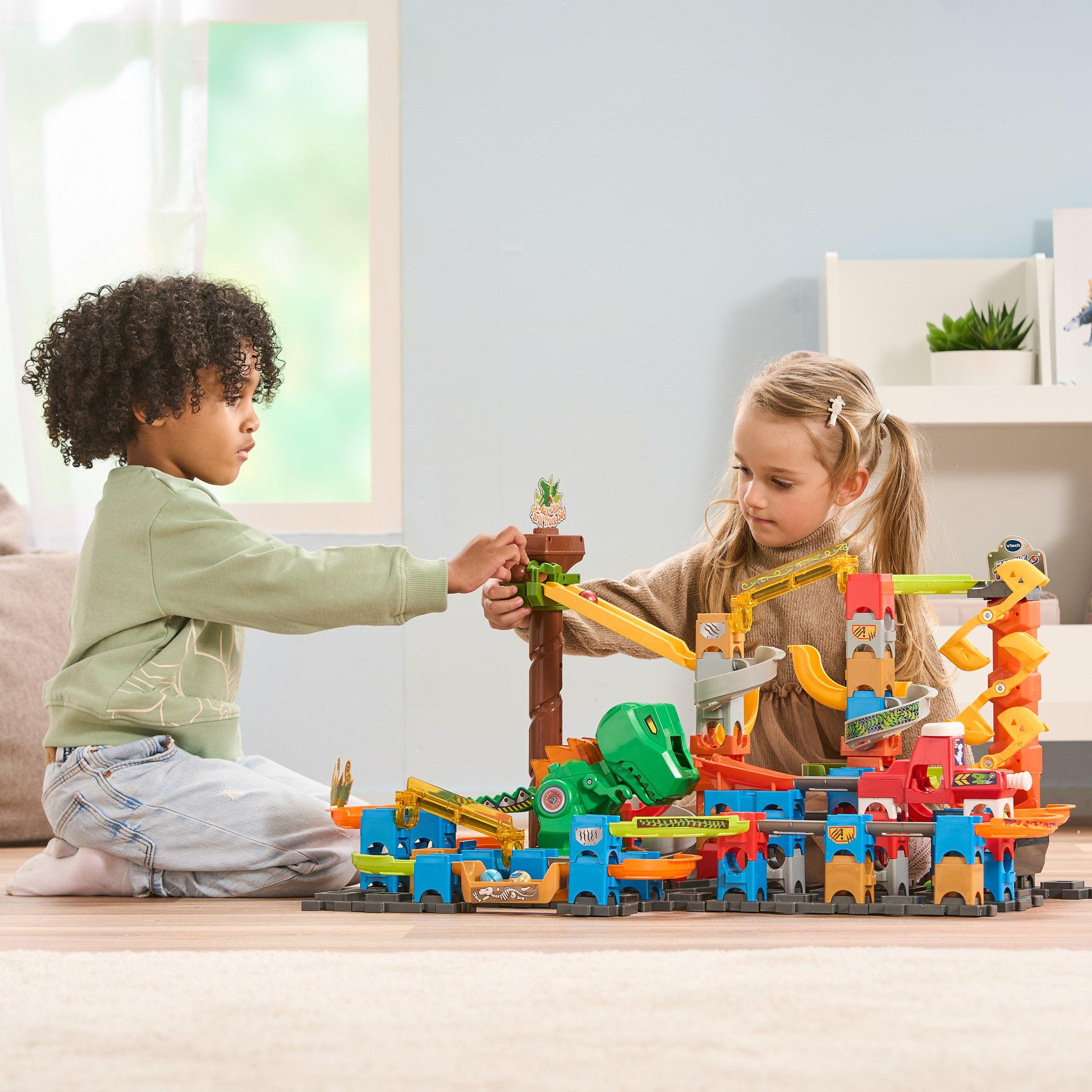 Two kids playing with Vtech toys on the floor